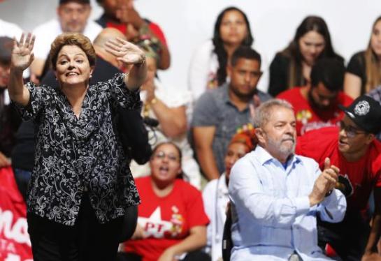 Brazil's President and Workers' Party (PT) presidential candidate Rousseff waves next to Brazil's former President Luiz Inacio Lula as they attend a campaign rally in Sao Paulo
